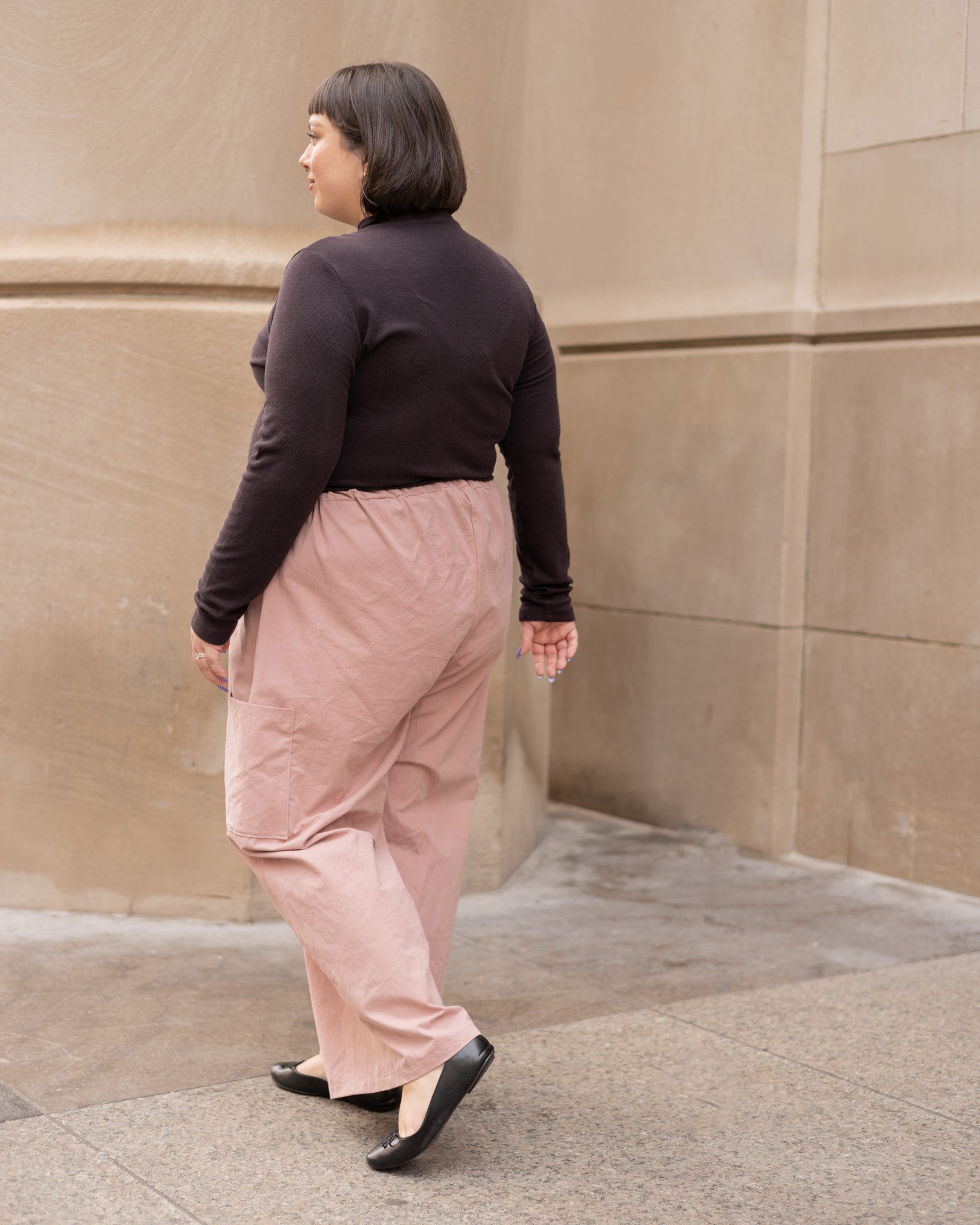 blush pink cargo pants worn with dark brown turtleneck