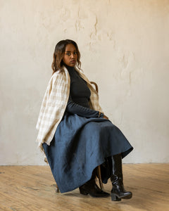 Model wearing an all blue outfit with a checkered scarf on her shoulders
