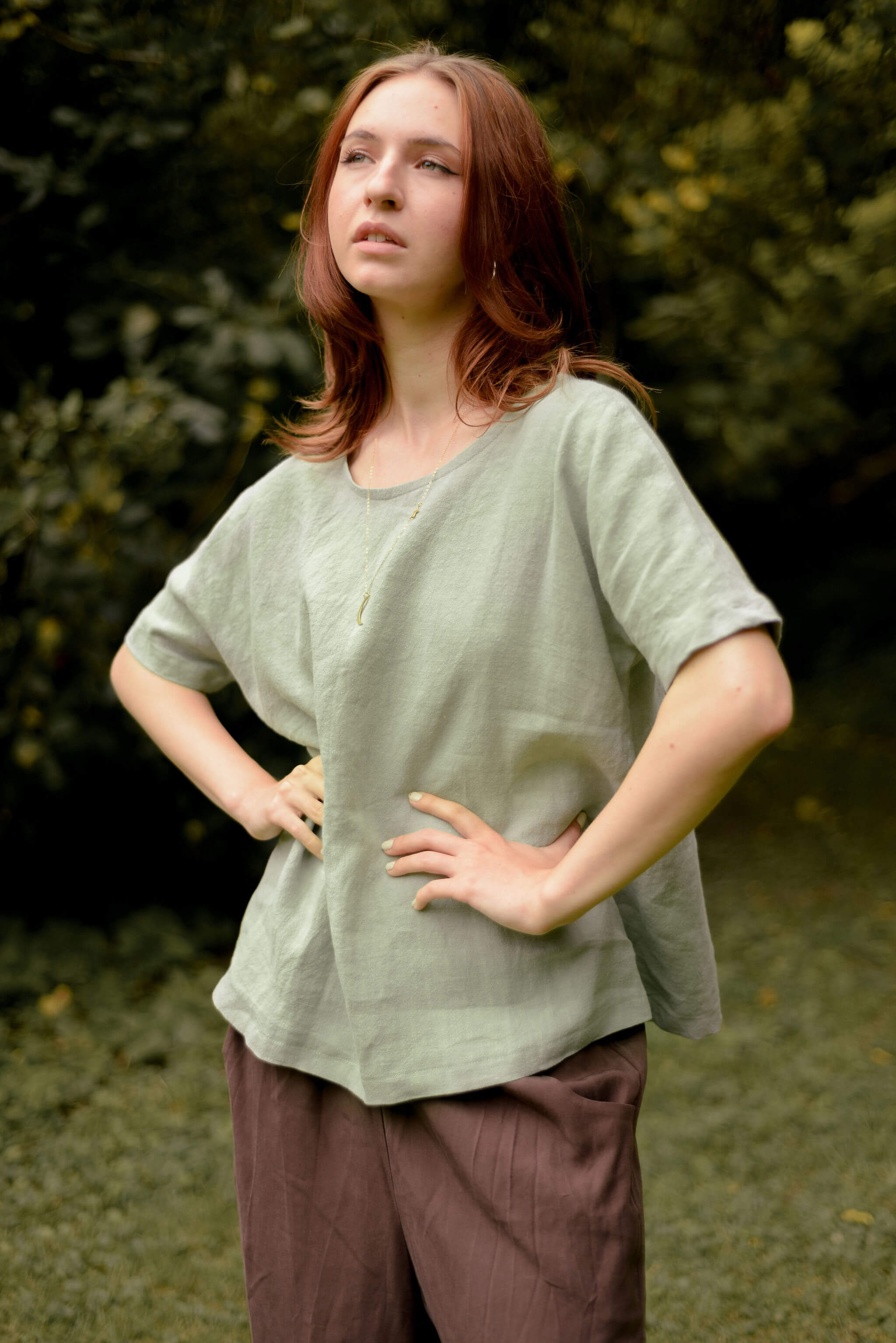 Flowy round neck short sleeve top in soft green worn with brown pants