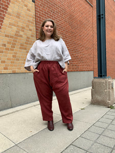 Model wears burgundy slouch pants and over sized grey top