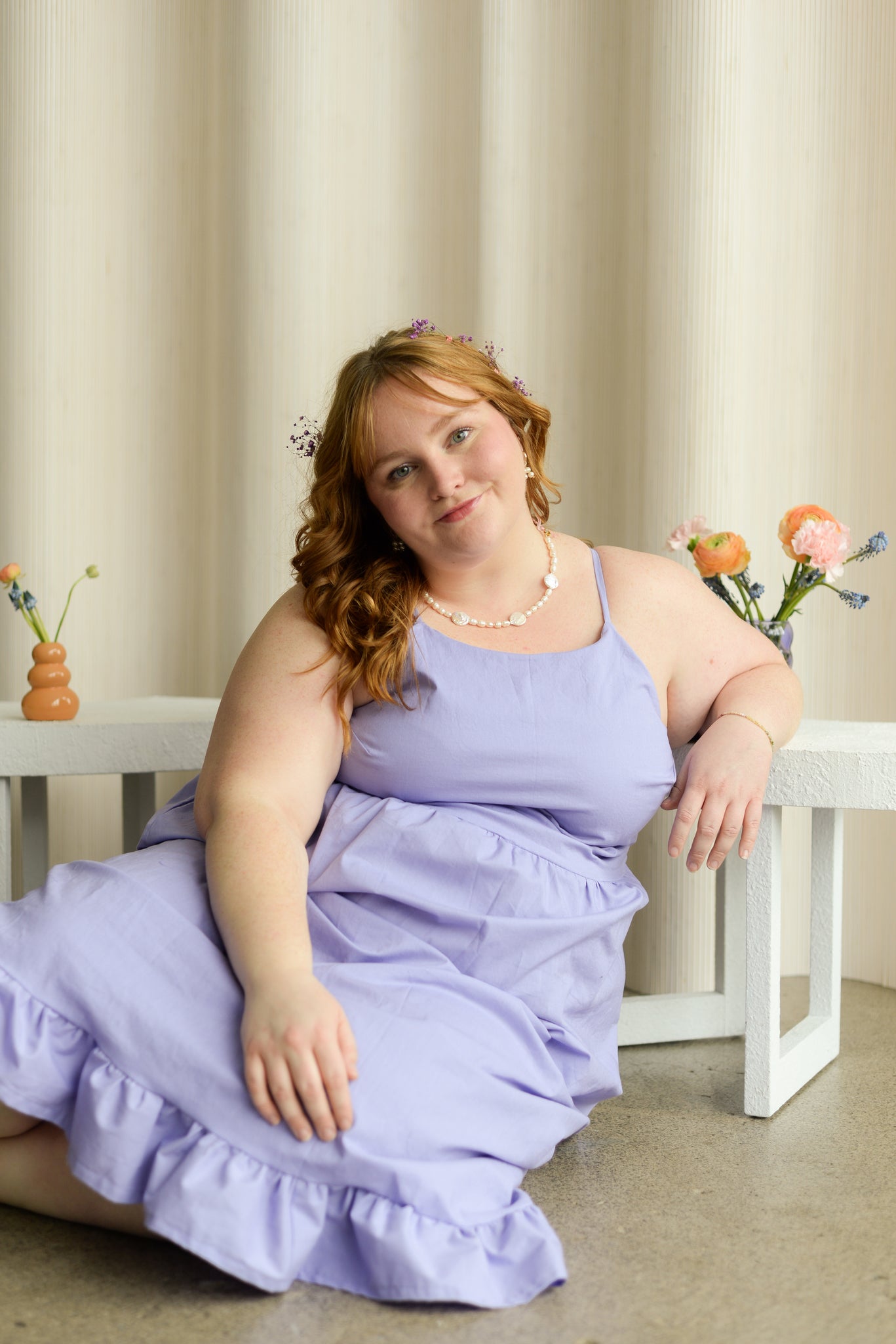 plus size model sitting on the floor while wearing a lavender organic cotton summer dress