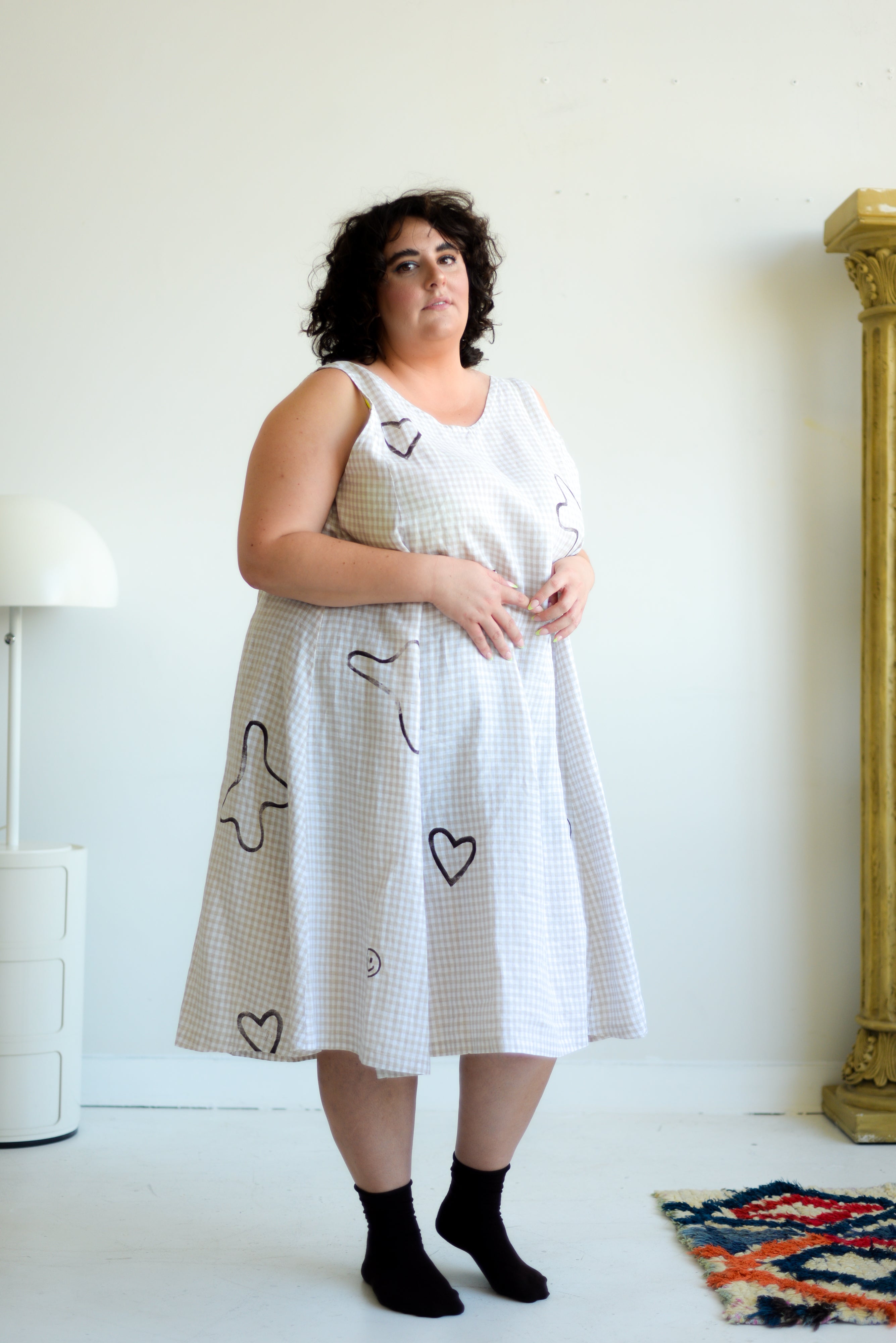 plus model wearing beige and white gingham sleeveless midi dress