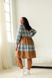 plus size model wearing a plaid and brown tiered dress 