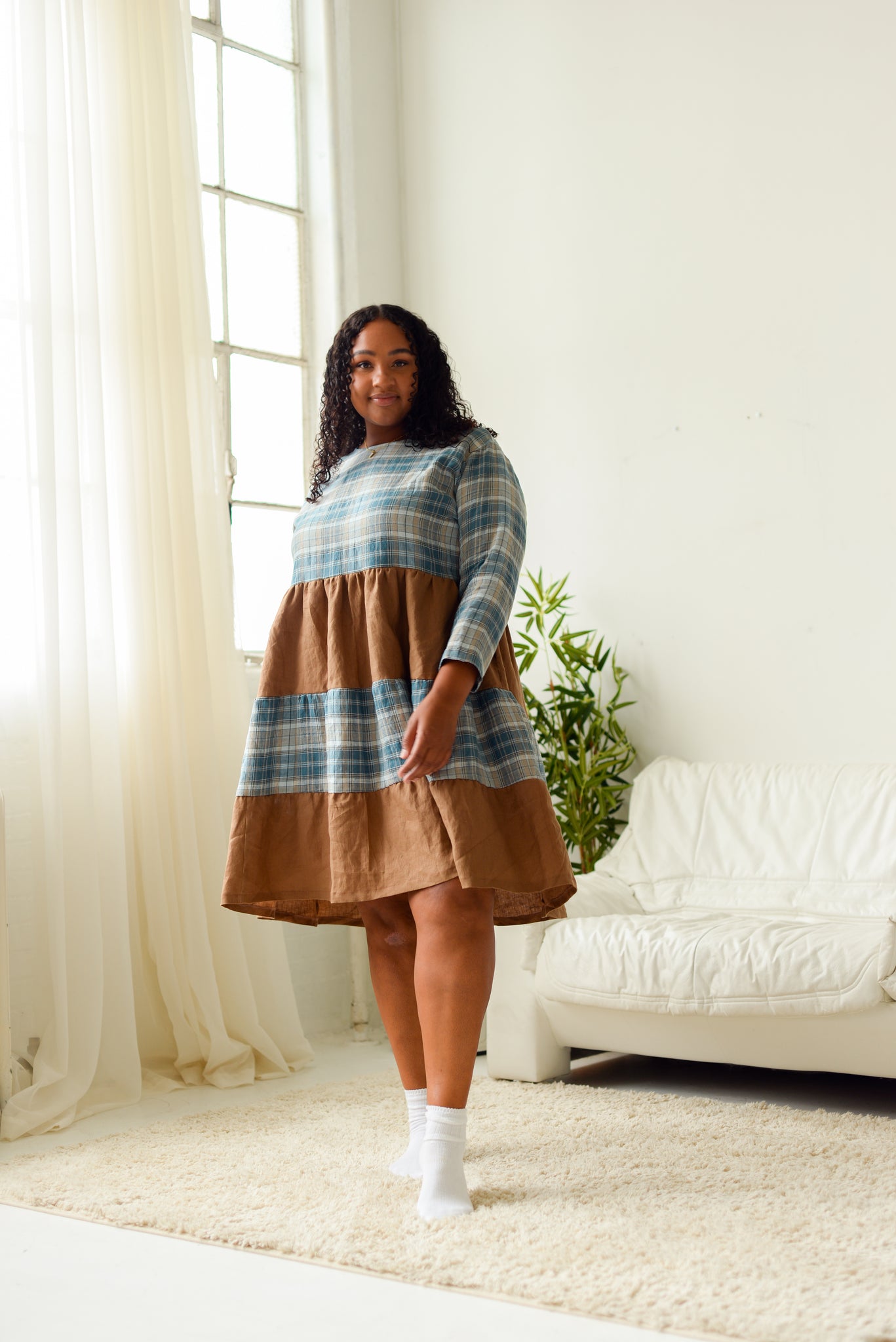 plus size black woman wearing a color/print blocked tiered long sleeve loose fitting dress